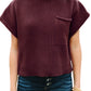 Dressed in a Patch Pocket Ribbed Knit Short Sleeve Sweater by Shewin, maroon in color, paired with dark blue jeans—ideal for transitional weather.