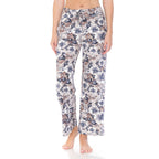 Someone stands barefoot against a plain white background, wearing Leggings Depot's Buttery Soft Print Pajama Pants featuring an elastic waistband and a colorful floral pattern.