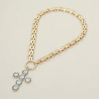 Sensibling Corp. Pearl Cross Charm Pendant Chunky Chain Statement Necklace displayed on a neutral background, featuring a bold gold chain and a large, textured cross adorned with round, silver-toned settings.