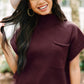 A person embraces the casual style of transitional weather, smiling at the camera while wearing a wide-brimmed hat and a Shewin Patch Pocket Ribbed Knit Short Sleeve Sweater, standing outdoors with trees in the background.