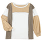 A long-sleeve top with a unique color block design in white, beige, and versatile khaki tones. The Shewin Khaki Color Block Exposed Seam Long Sleeve Top features a round neckline and slightly puffy sleeves.