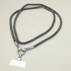 A Sensibling Corp. Rhinestone Phone Lanyard Necklace featuring metallic clasps and a blank rectangular identification badge is displayed on a light-colored surface.