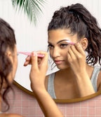 A person using Lemon Lavender Light Up Tweezer LED spotlight tweezers to groom their eyebrows in front of a mirror.