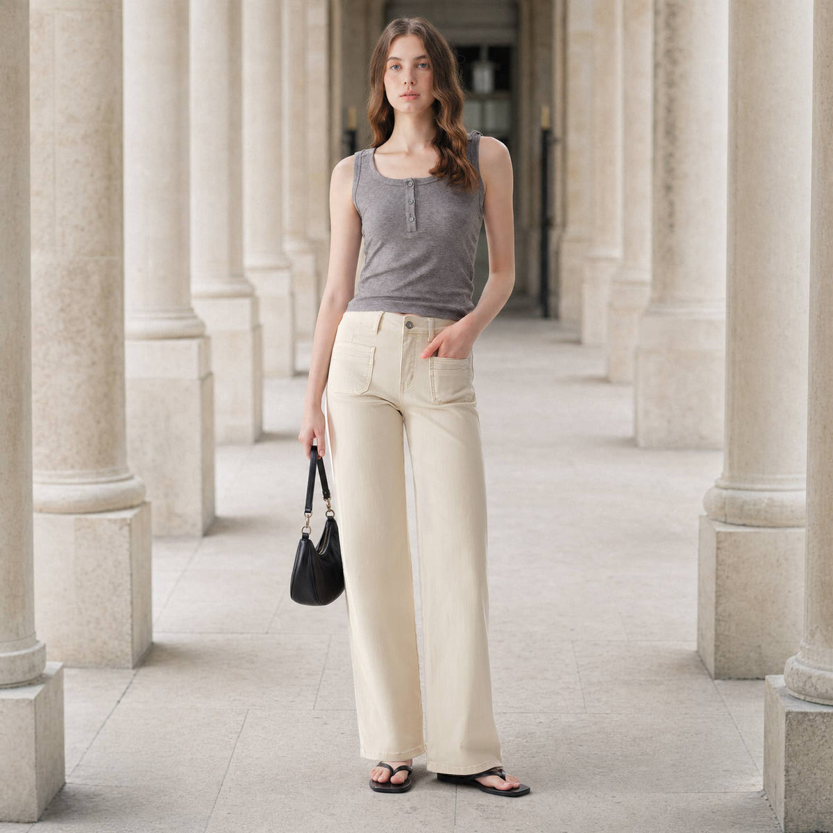 A woman wearing a gray tank top and Faire Off White Mid Rise Straight Pants with patch pockets, holding a black handbag. Main image