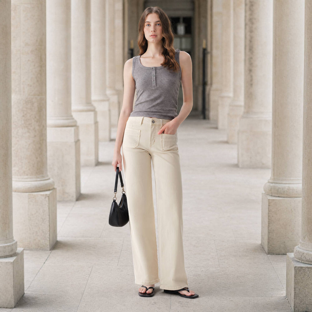 A woman wearing a gray tank top and Faire Off White Mid Rise Straight Pants with patch pockets, holding a black handbag.