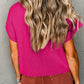 Someone with long wavy hair wearing a Shewin Patch Pocket Ribbed Knit Short Sleeve Sweater in pink and brown pants stands facing a gray wall, perfectly dressed for transitional weather.