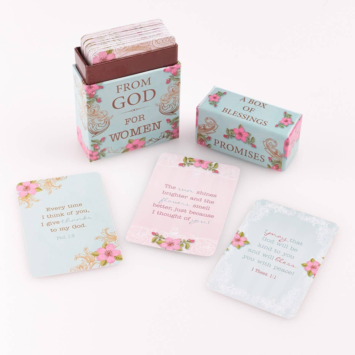 A floral-themed box labeled "Box of Blessings Promises for Women" from Christian Art Gifts features beautifully designed Bible verse cards, elegantly displayed in front.