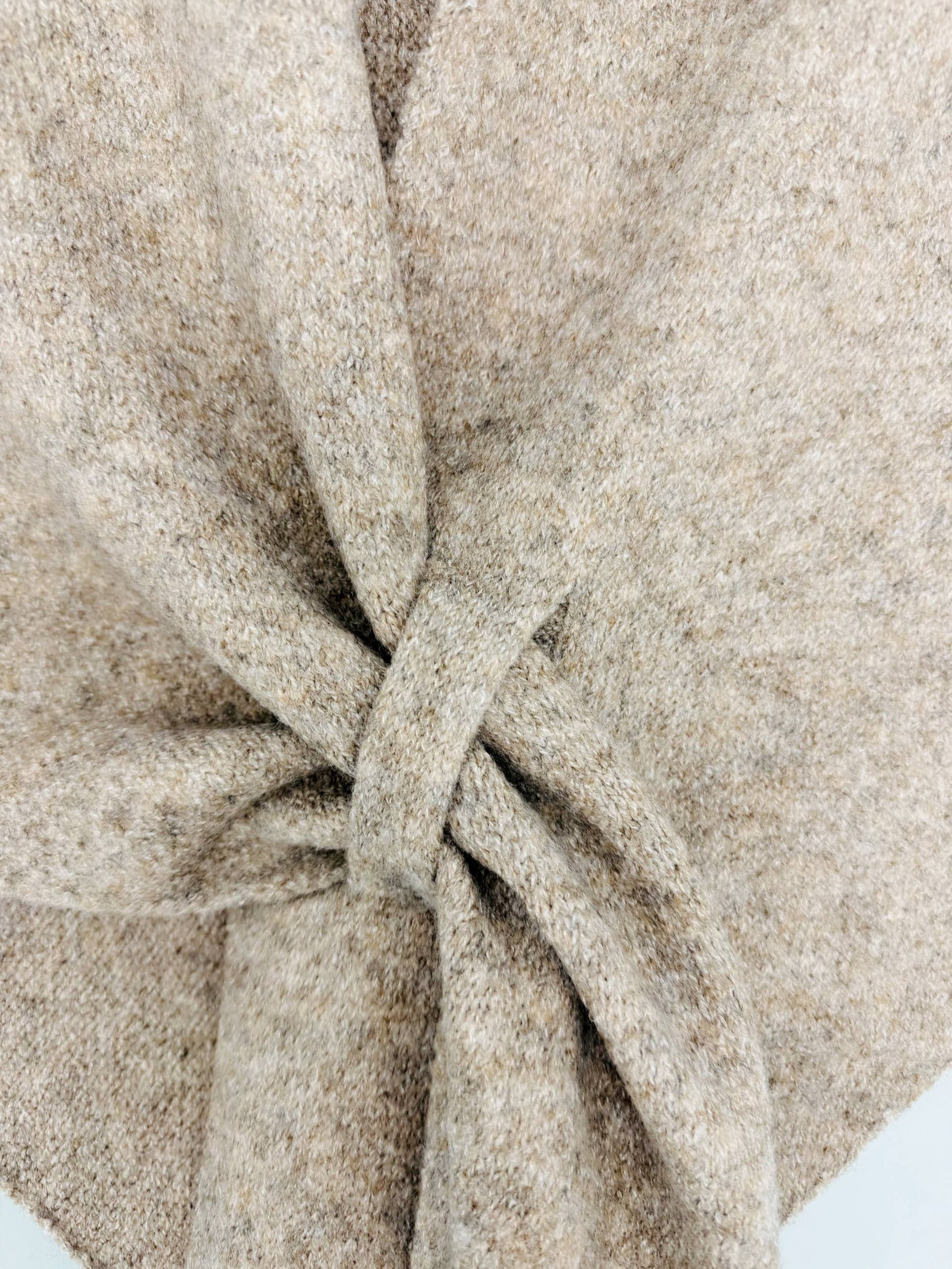 Close-up of the JC Sunny Fashion Cashmere-Blend Knit Triangle Shawl, featuring its stylish cross-front design and showing off the cozy fabric's texture and weave.