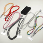Several colorful lanyards by Sensibling Corp. are arranged on a light surface, each with attached blank name tags and a smartphone. One is the Rhinestone Phone Lanyard Necklace, featuring a sparkling rhinestone strap that adds a touch of style; another design cleverly doubles as a convenient cell phone holder.