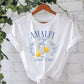 The Rosa Clothing Stylish Lemon Graphic Print Crew Neck T-Shirt features "Amalfi Coast Italy Social Club" text and a lemon with laurel illustrations on the front, shown in white on a hanger.