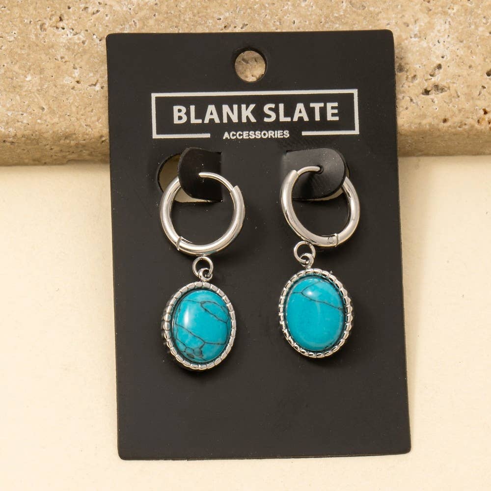 Anarchy Street's Oval Turquoise Stone Drop Earrings feature silver hoops and turquoise pendants, displayed on a black card. Made of stainless steel, these earrings add an elegant touch to any outfit.