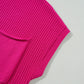 Close-up of a Shewin Patch Pocket Ribbed Knit Short Sleeve Sweater, in pink, against a light gray background.