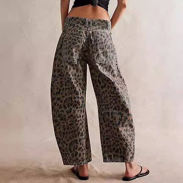 A person models Dipped Shop's Leopard Print Loose Midi Waist Wide Leg Jeans with black sandals, standing with their back to the camera against a plain background.