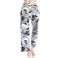 A person is shown from the back wearing Leggings Depot Buttery Soft Print Pajama Pants with an elastic waistband and black and white floral pattern, standing barefoot against a white background.