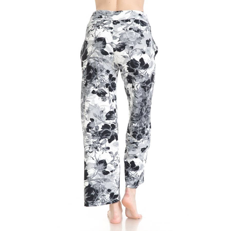 A person is shown from the back wearing Leggings Depot Buttery Soft Print Pajama Pants with an elastic waistband and black and white floral pattern, standing barefoot against a white background.
