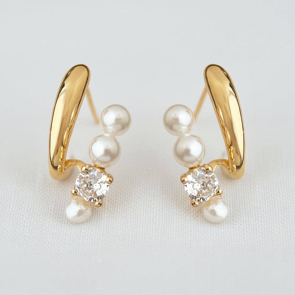 Experience timeless elegance with the Ellemadera Zircon Pearl Dangle Earrings. These earrings feature a graceful curved gold design, each adorned with three radiant white pearls and a sparkling clear zircon gemstone. Perfect for those who appreciate classic sophistication, the earrings are beautifully displayed against a simple white background.