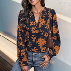 Faire Navy and Orange Print Pull Over Blouse in lightweight navy with an orange floral print, V-neckline, button cuffs, and a patterned design.