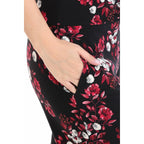 Close-up of a hand in the pocket of Leggings Depot Buttery Soft Print Pajama Pants, featuring a black base with red and white floral design.