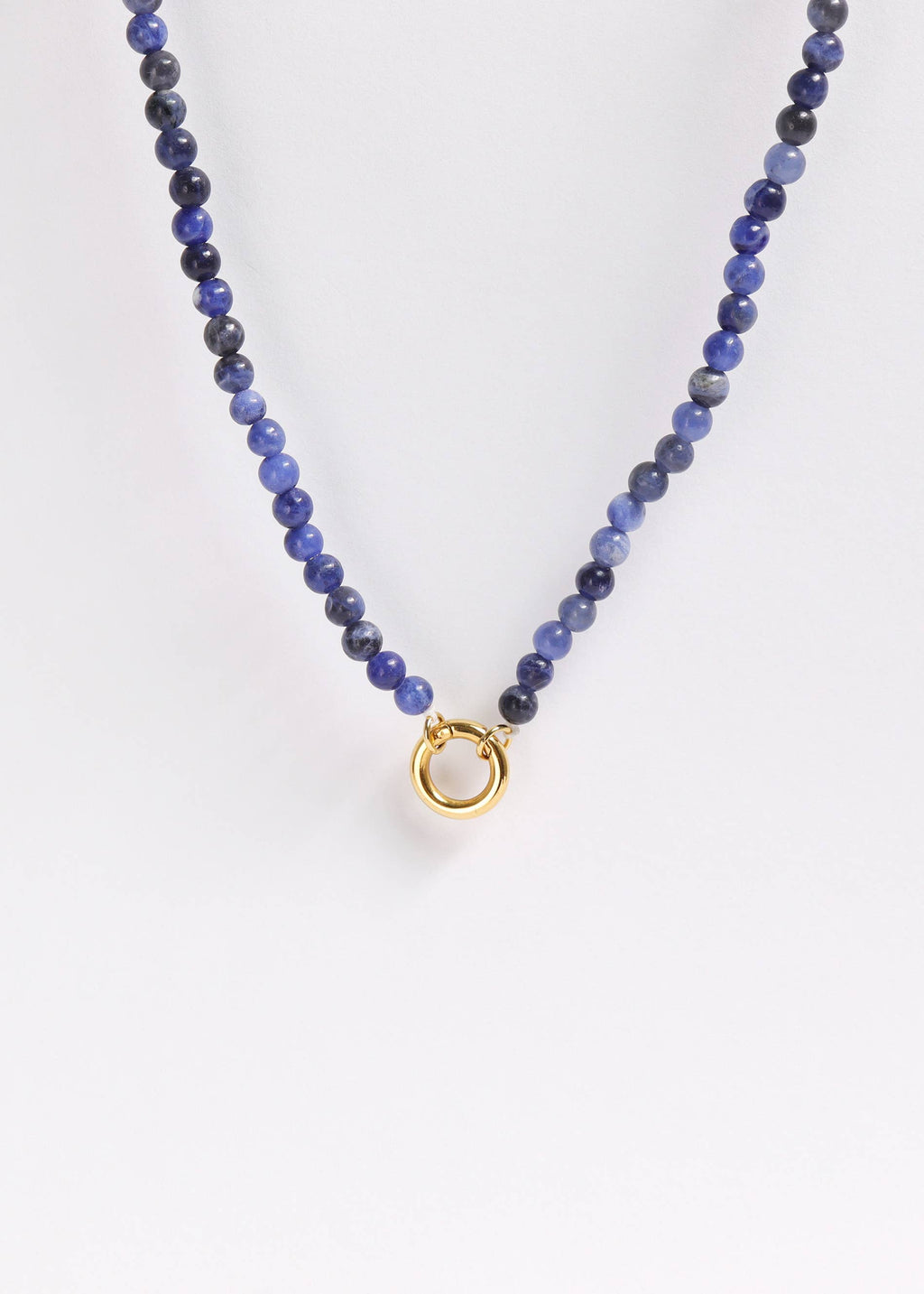 The WJW Semi Precious Natural Stone Charm Keeper Necklace showcases round blue semi-precious stones and is finished with an elegant circular clasp coated in 18K Gold PVD, beautifully presented against a plain white background.