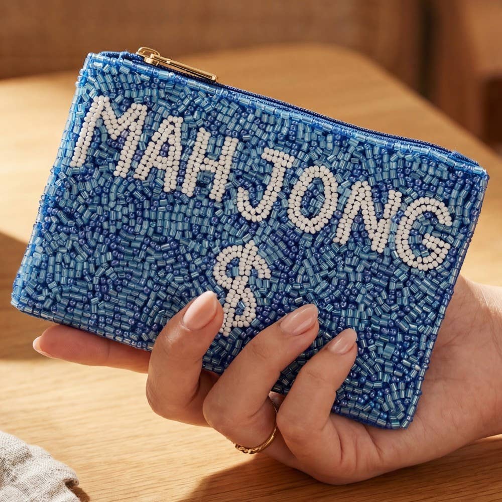 A hand holds the Blue Mahjong Money Seed Beaded Coin Purse by Anarchy Street, featuring white seed bead accents, a zipper, and “MAHJONG $” spelled out in bold beaded letters.