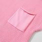 The Shewin Patch Pocket Ribbed Knit Short Sleeve Sweater in pink, ideal for transitional weather, features a large front pocket and is laid flat.