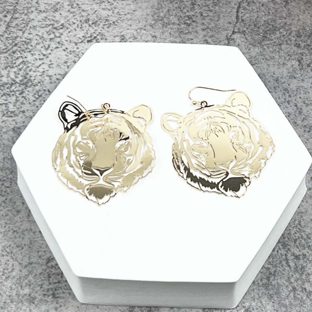 Two ITS ME10288 TIGER earrings by SPECIAL EFFECTS displayed on a hexagonal white surface.