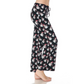Standing barefoot on a white background, a person wears FASHION GO's buttery soft, black pajama pants adorned with a snowman pattern. These cozy pajama pants, officially named "Buttery Soft Pajama Pants with Drawstring," feature an elastic waistband for ultimate comfort and functional pockets for keeping essentials close by.