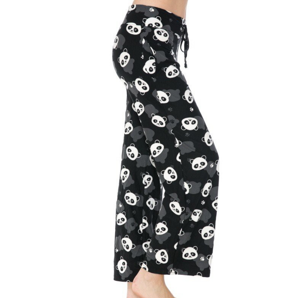 Dressed in FASHION GO's buttery soft pajama pants featuring a playful white panda print and an elastic waistband, a person stands barefoot, savoring the ultimate comfort.