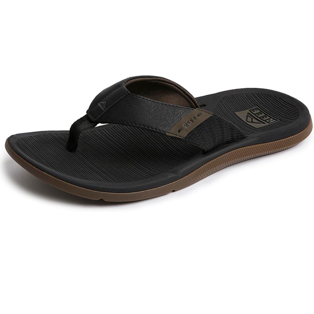 The Santa Anna Men's Flip-Flop in Black by REEF boasts a textured strap with a brown sole and ridged footbed. Designed with a non-marking outsole, it ensures excellent traction on various surfaces. This water-friendly flip-flop also offers arch support for enhanced all-day comfort.