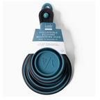 The Krumbs Kitchen Silicone Collapsible Measuring Cups 4pc Set by DM MERCHANDISING INC features blue silicone cups designed for easy storage. They stack neatly, and the collapsible, heat-resistant design is highlighted on a label with brand and product details.