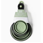 The Krumbs Kitchen Silicone Collapsible Measuring Cups 4pc Set by DM MERCHANDISING INC features heat-resistant cups in various sizes, nesting together. The top cup measures 1/4, and the black handle includes a hanging loop for convenient storage.