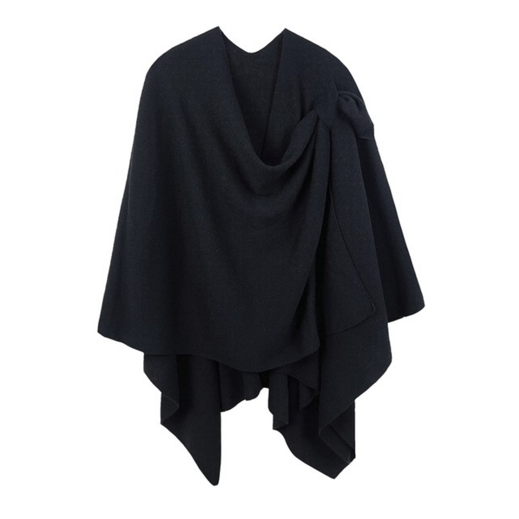 A black Soft Solid Color Ruana with Strap Hold from FASHION GO, featuring a loose, flowing design and an asymmetrical hem.