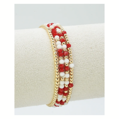 The FASHION GO Set of 4 Glass Bead and Gold Stretch Bracelets features alternating red and white beads—perfect for gameday to show off your team colors in style.