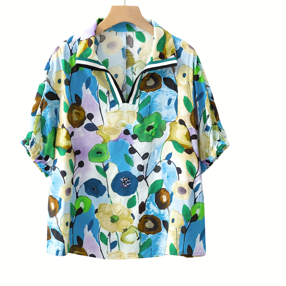A Floral Print Boho Pop of Color Neckline Blouse by Shewin hangs vibrantly with a quarter-zip collar, showcasing blue, green, yellow, and black flowers on a light backdrop.
