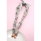 The FASHION GO Handmade Scarf Necklace in assorted colors and patterns is shown on a pink background beside a white plate.