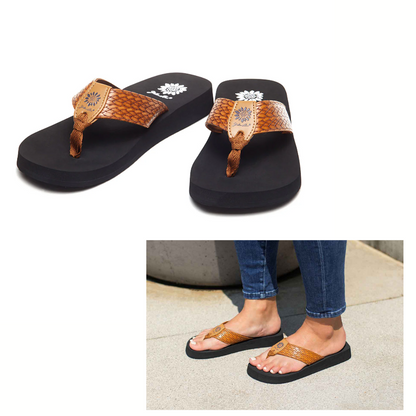 The Flax Flip Flop by Yellow Box features brown and black faux leather straps, shown solo on a white background and paired with jeans outdoors.