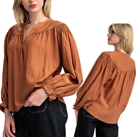 Two views of a woman wearing the Crinkle Notched Neck Long Sleeve Top in Cinnamon by FASHION GO, showcasing its loose fit and gathered details on the shoulders and cuffs. This chic blouse, with its notched neckline, is paired perfectly with dark jeans.