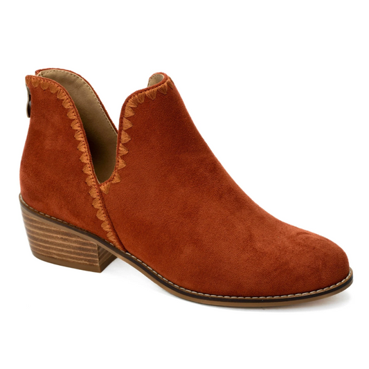 The Spice It Up Boot in Rust by Corky's from CORKY'S FOOTWEAR INC features a single rust-colored suede ankle boot with an open ankle design, a stacked heel, and decorative stitching along the top edge, complemented by a cushioned footbed for added comfort.