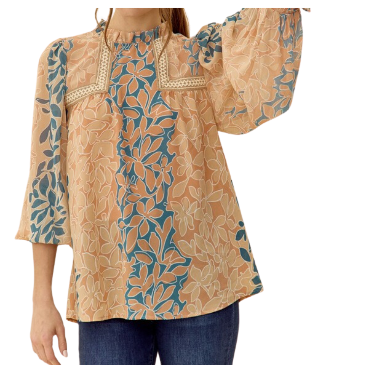 A person wearing a Plant Print Blouse in Peach from FASHION GO featuring peasant sleeves and paired with blue jeans. Only the upper body and part of the arm are visible.