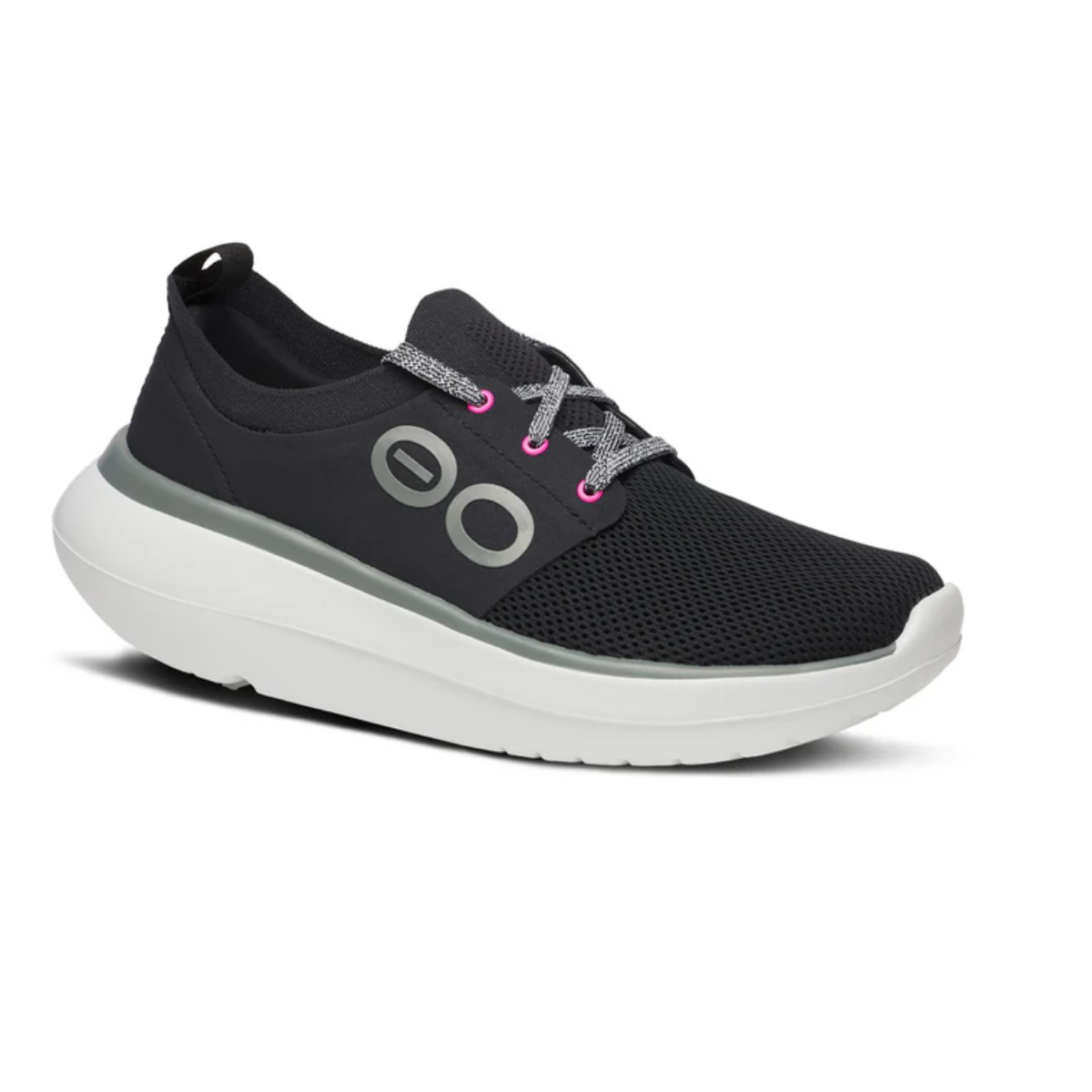 The Oohmy Stride in Black/White by OOFOS LLC is a black athletic sneaker with a breathable stretch upper, gray logo, gray laces with pink-accented eyelets, and a thick white sole for impact absorption. Main image