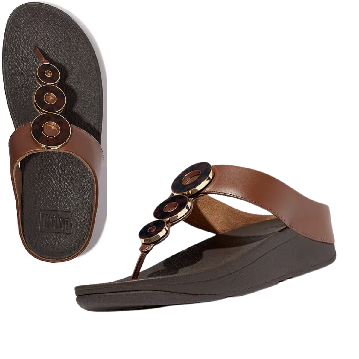 A pair of Fino Resin Hoop Flip Flops by FIT FLOPS in brown, featuring circular decorative elements, black cushioned soles, and Microwobbleboard™ midsoles for extra comfort. Main image