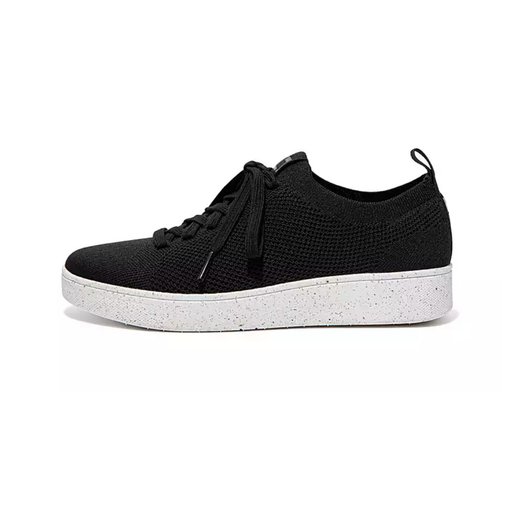 A side view of the black Rally e01 Knit Tennis Shoes by FITFLOP USA LLC, featuring a white speckled sole, highlights the future of sustainable footwear.