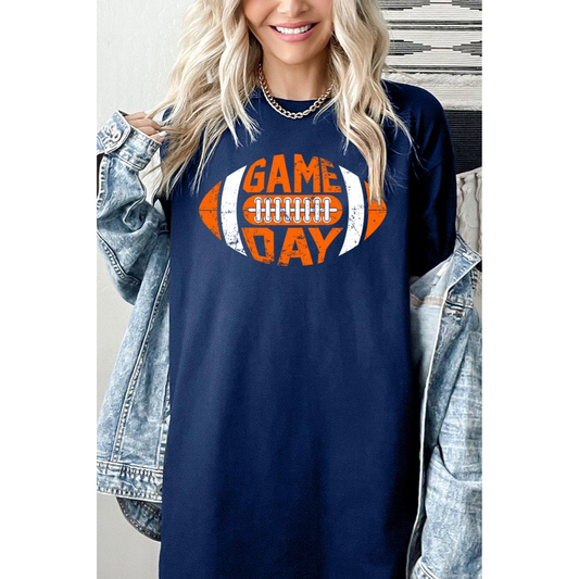 A person is sporting a blue FASHION GO Game Day Football Graphic T with a football design, layered stylishly under a denim jacket—perfect for casual outings.