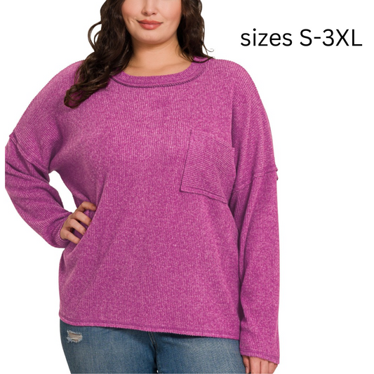 A person wearing a Ribbed Brushed Melange Hacci Sweater with Pocket in light plum by FASHION GO and blue jeans. Text on the image reads "sizes S-3XL".