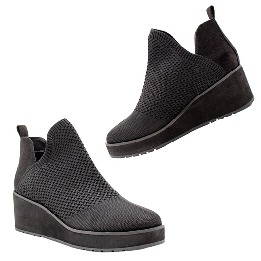 A pair of black slip-on wedge ankle booties featuring a stretch knit upper and thick soles, known as the Albright Knit Bootie in Black by Volatile from Rosenthal & Rosenthal.