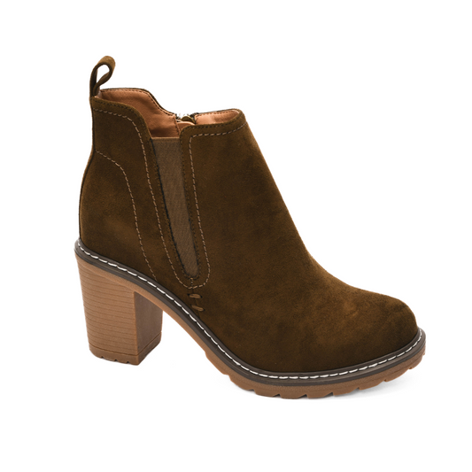 The Bite Me Boot in Khaki Faux Suede by Corky's is a striking bootie featuring a 3" chunky wooden heel, adorned with a side zipper and completed with a durable rubber sole.