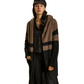 A woman models the Umgee Color Block Cardigan Sweater with Hoodie & Side Pockets in black and brown, styled with black pants and a black cap, standing against a white background.