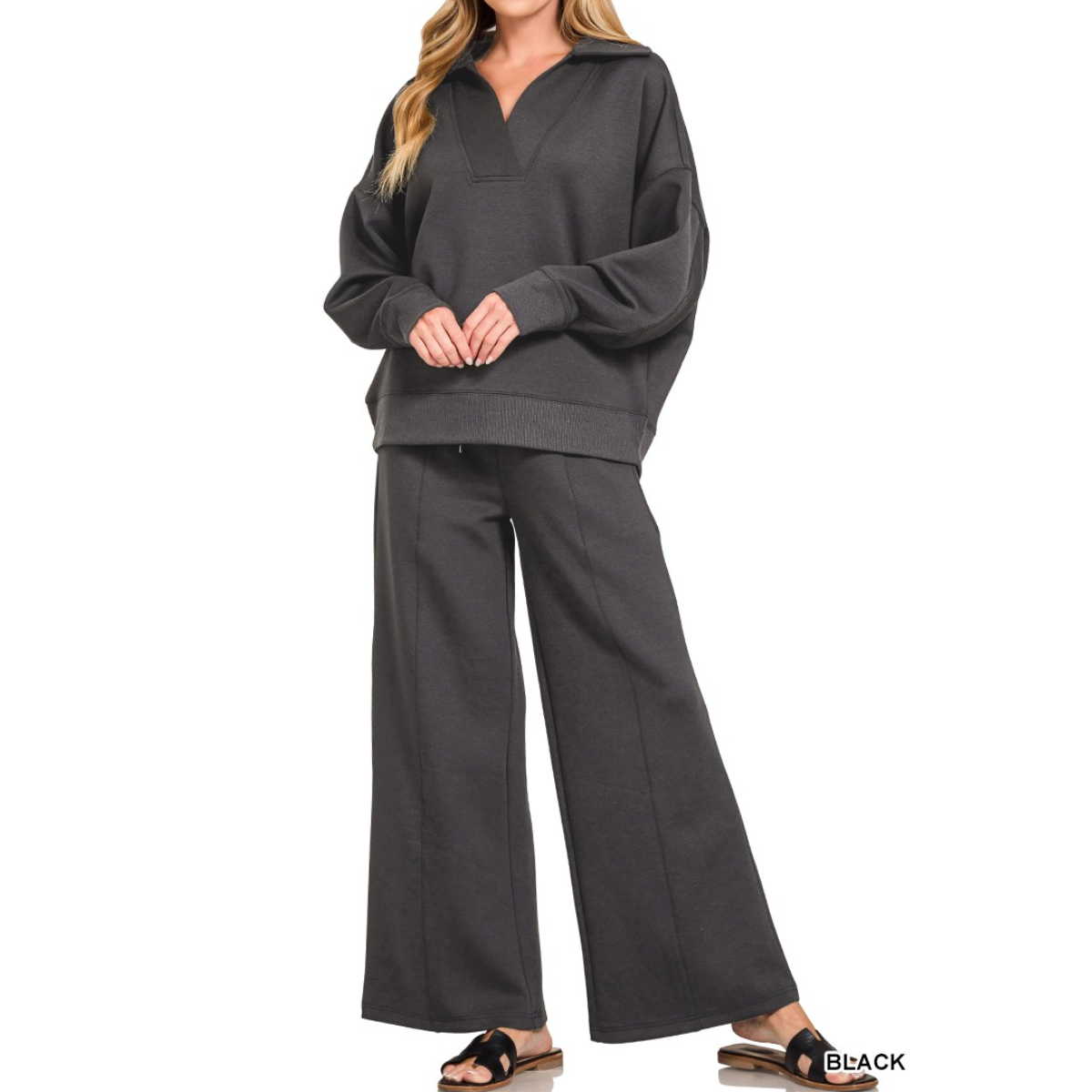 A woman wears the Zenana Scuba Collared Pullover and Pants Set with slide sandals, standing against a white background. This durable scuba fabric set offers a modern look and ultra-comfortable fit. Main image