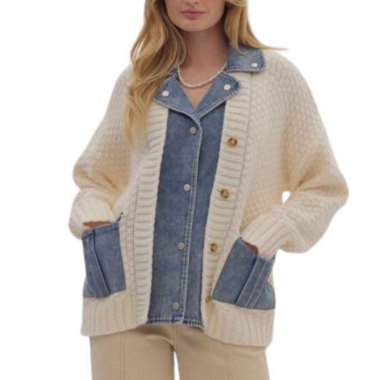 A woman stands confidently with her hands in her pockets, wearing the Denim Sweater Jacket by Entro, featuring a cream cardigan design with faux snap denim lapels over a stylish button-up denim top.