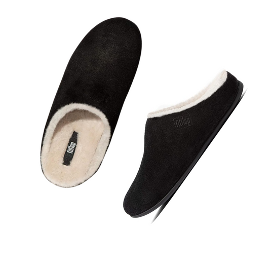 A pair of Chrissie Shearling Slippers in Black by Fit Flops from FITFLOP USA LLC, featuring plush white fleece lining and iQushion midsoles, displayed in top and side views against a white background.